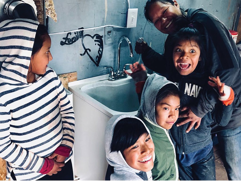 A family near a water tap