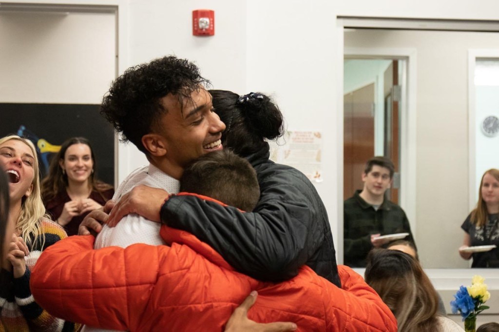 Three people giving each other a celebratory hug