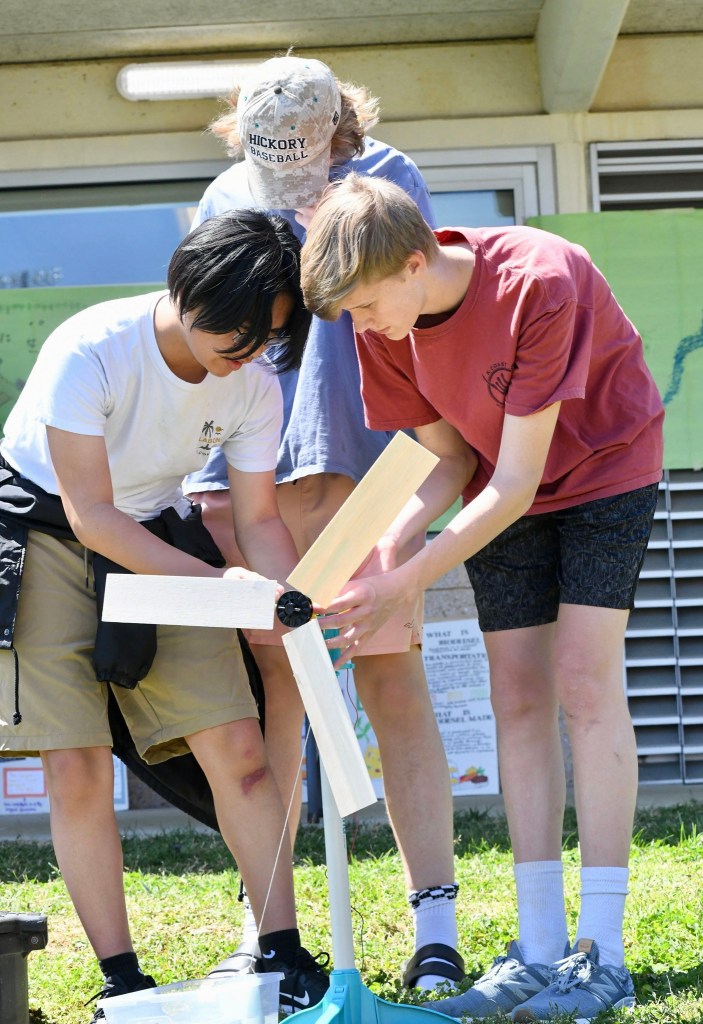 Three teenagers working on an outdoor science project in Henrico, Virginia
