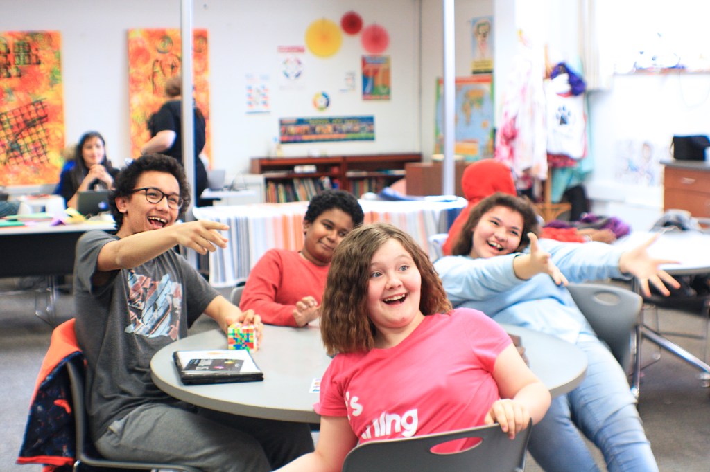 Four happy kids smiling around a round table