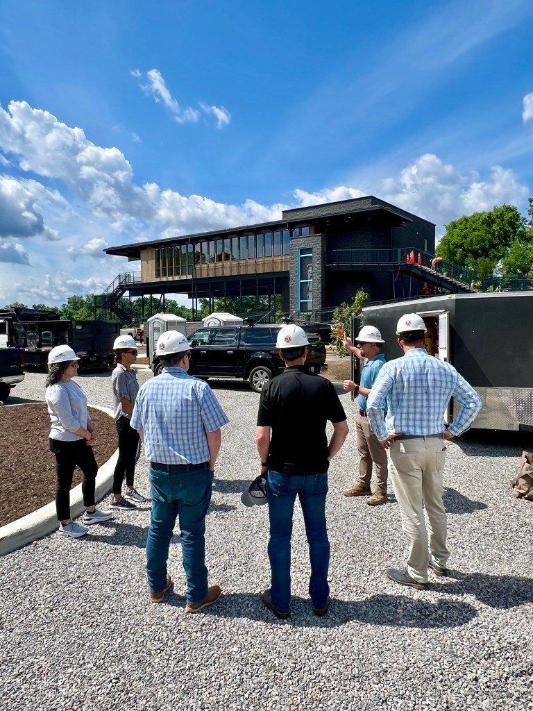 A group of people in front of the James A. Buzzard River Education Center construction.