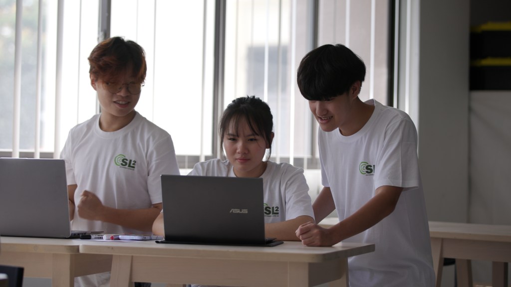 A group of students learning in front of a laptop