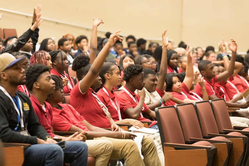 A group of students raising their hands